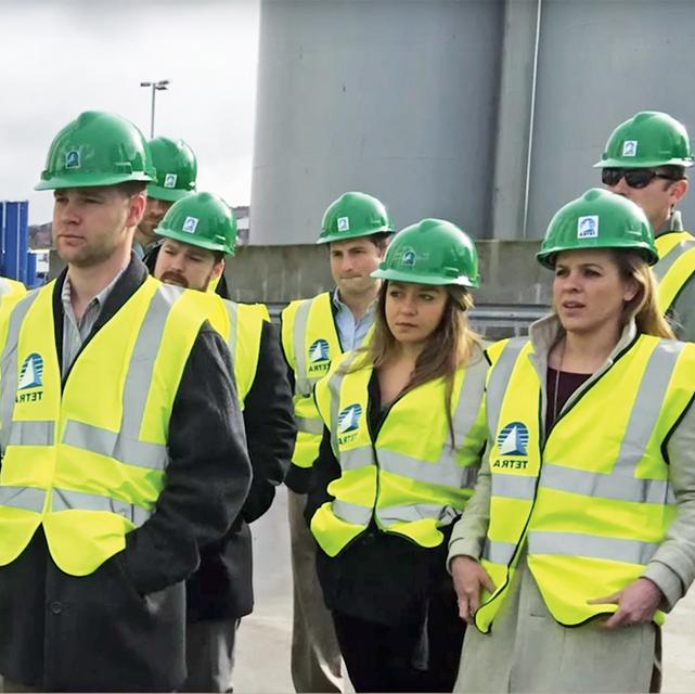 Group of Energy MBA students on site wearing hard hats and safety vests